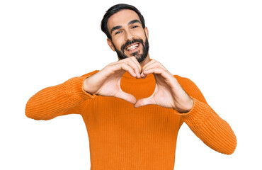 Wall Mural - Young hispanic man wearing casual clothes smiling in love doing heart symbol shape with hands. romantic concept.