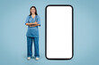 © Prostock-studio - Young caucasian nurse by large phone screen, blue background
