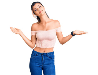 Poster - Young beautiful woman wearing casual clothes clueless and confused expression with arms and hands raised. doubt concept.