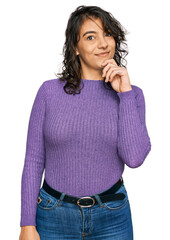 Wall Mural - Young hispanic woman wearing casual clothes looking confident at the camera with smile with crossed arms and hand raised on chin. thinking positive.