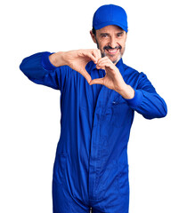 Sticker - Middle age handsome man wearing mechanic uniform smiling in love doing heart symbol shape with hands. romantic concept.