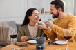 © New Africa - Affectionate couple enjoying chocolate fondue during romantic date at home
