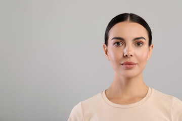 Wall Mural - Portrait of beautiful young woman on grey background. Space for text