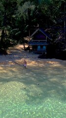 Wall Mural - Koh Wai Island Trat Thailand Koh Chang. wooden bamboo hut bungalow on the beach and a young couple of men and women walking at the beach on a tropical Island in Thailand during vacation