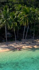 Wall Mural - Koh Wai Island Trat Thailand near Koh Chang. wooden bamboo hut bungalow on the beach and a young couple of men and woman walking at the beach on a tropical Island in Thailand during vacation