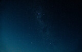 Fototapeta Niebo - Starry night sky filled with luminous stars, illuminating the dark blue expanse.