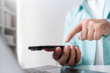 Close up of hands man hand using smartphone typing, chatting conversation in chat box. Man hands using smartphone in office, messaging or browsing social networks.