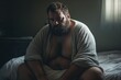 © CStock - Sad heavy man sitting on bed at home, health problem, depression,