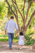 © natrocfort - Family members holding hands and walking backwards in a park together family