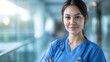 © RISHAD - Confident nurse in blue scrubs smiling.