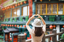 Woman Traveler Visiting In Taiwan, Tourist With Hat Sightseeing In Jiufen Old Street Village With Tea House Background. Landmark And Popular Attractions Near Taipei City . Travel And Vacation Concept