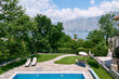 Pool in the garden of a cozy villa with sun loungers and mountain views
