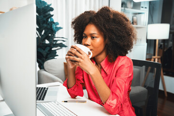 Poster - Young African businesswoman focusing project on screen monitor laptop, researching information data center on website pc and smartphone. Theme of place work in comfy room with plain color. Tastemaker.