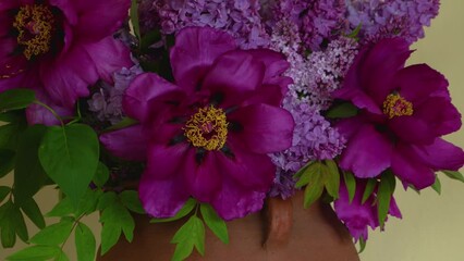 Poster - bright spring bouquet. Large delicate purple flowers of a tree peony and lilac branches stand in a large clay vase in an open gazebo in a private yard. Lilac bushes are visible through the open