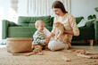 © Westend61 - Mother holding cat and playing with son in the living room