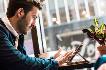 Businessman using tablet PC at cafe