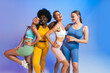 © Westend61 - Happy female friends standing together against colored background