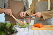 Cropped shot senior couple cooking healthy vegan meal together in kitchen. Healthy eating concept.