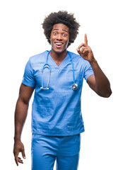 Sticker - Afro american surgeon doctor man over isolated background pointing finger up with successful idea. Exited and happy. Number one.