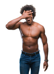 Canvas Print - Afro american shirtless man showing nude body over isolated background peeking in shock covering face and eyes with hand, looking through fingers with embarrassed expression.