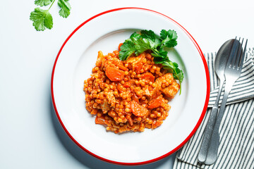 Wall Mural - Ptitim with chicken, vegetables and cilantro, white background. Traditional Israeli food.