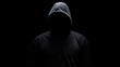 A striking silhouette of a hooded person, embodying the enigma of a hacker in the dark, isolated against a black background, evoking a sense of cybersecurity intrigue and danger