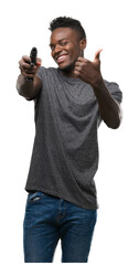 Poster - Young african american man holding a gun pointing with hand and finger up with happy face smiling