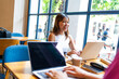 © ADDICTIVE STOCK - A cheerful Asian woman working on a laptop in a bright cafe, with a Caucasian woman during remote work environment in Chiang Mai, Thailand