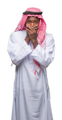 Canvas Print - Young arabic african man wearing traditional keffiyeh over isolated background shocked covering mouth with hands for mistake. Secret concept.