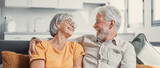 Fototapeta  - Happy laughing older married couple talking, laughing, standing in home interior together, hugging with love, enjoying close relationships, trust, support, care, feeling joy, tenderness.