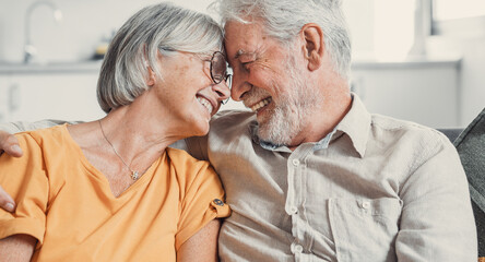 Happy laughing older married couple talking, laughing, standing in home interior together, hugging with love, enjoying close relationships, trust, support, care, feeling joy, tenderness.