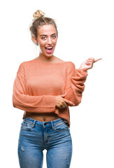 Sticker - Beautiful young blonde woman over isolated background with a big smile on face, pointing with hand and finger to the side looking at the camera.