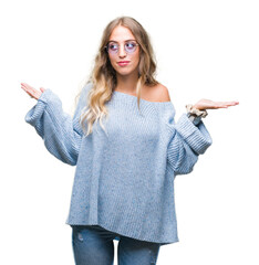 Poster - Beautiful young blonde woman wearing sunglasses over isolated background clueless and confused expression with arms and hands raised. Doubt concept.