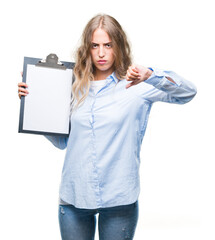 Poster - Beautiful young blonde business woman holding clipboard over isolated background with angry face, negative sign showing dislike with thumbs down, rejection concept