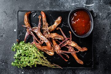 Canvas Print - Chinese food dip fried duck tongue Black background. Top view