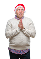 Sticker - Handsome senior man wearing christmas hat over isolated background begging and praying with hands together with hope expression on face very emotional and worried. Asking for forgiveness