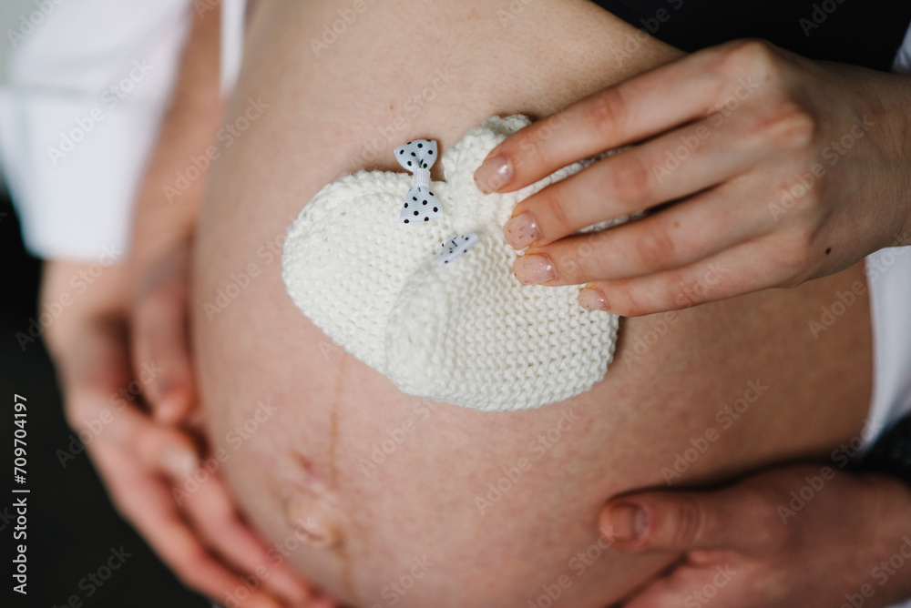 Pregnant woman and man holding white socks for a baby boy on her ...