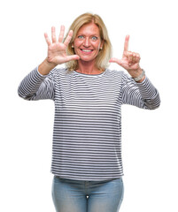 Poster - Middle age blonde woman over isolated background showing and pointing up with fingers number seven while smiling confident and happy.