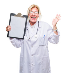 Sticker - Middle age blonde doctor woman holding clipboard over isolated background very happy and excited, winner expression celebrating victory screaming with big smile and raised hands