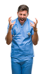 Wall Mural - Young handsome doctor nurse man over isolated background celebrating mad and crazy for success with arms raised and closed eyes screaming excited. Winner concept
