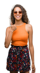 Wall Mural - Young hispanic woman wearing summer outfit happy with big smile doing ok sign, thumb up with fingers, excellent sign