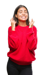 Canvas Print - Young beautiful arab woman wearing winter sweater over isolated background smiling crossing fingers with hope and eyes closed. Luck and superstitious concept.