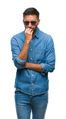 Sticker - Adult hispanic man wearing sunglasses over isolated background looking stressed and nervous with hands on mouth biting nails. Anxiety problem.