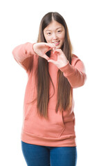 Sticker - Young Chinese woman over isolated background wearing sport sweathshirt smiling in love showing heart symbol and shape with hands. Romantic concept.