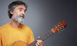 © luengo_ua - Aged bearded man with an acoustic guitar
