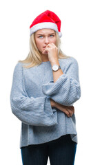 Poster - Young caucasian woman wearing christmas hat over isolated background looking stressed and nervous with hands on mouth biting nails. Anxiety problem.