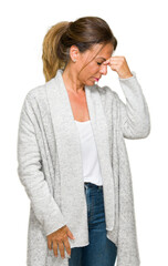 Wall Mural - Beautiful middle age adult woman wearing winter sweater over isolated background tired rubbing nose and eyes feeling fatigue and headache. Stress and frustration concept.