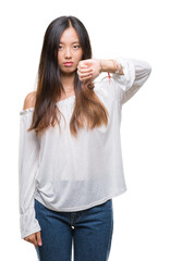 Wall Mural - Young asian woman over isolated background looking unhappy and angry showing rejection and negative with thumbs down gesture. Bad expression.