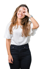 Wall Mural - Young beautiful brunette business woman over isolated background doing ok gesture with hand smiling, eye looking through fingers with happy face.