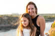 © Zarina Lukash - Happy mom and daughter relaxing on rocks in nature against the backdrop of the river. Happy Motherhood, Mother's Day